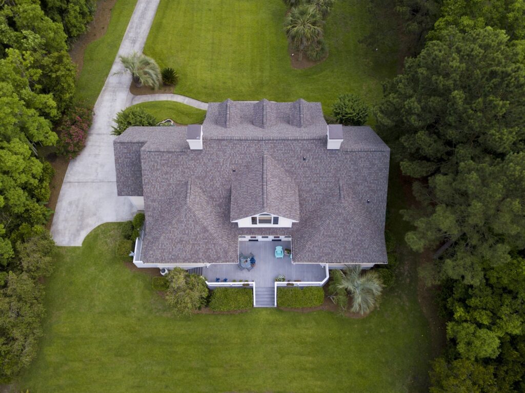 Aerial view of large home with new roof on beautiful property. - Roofing Services Princeton